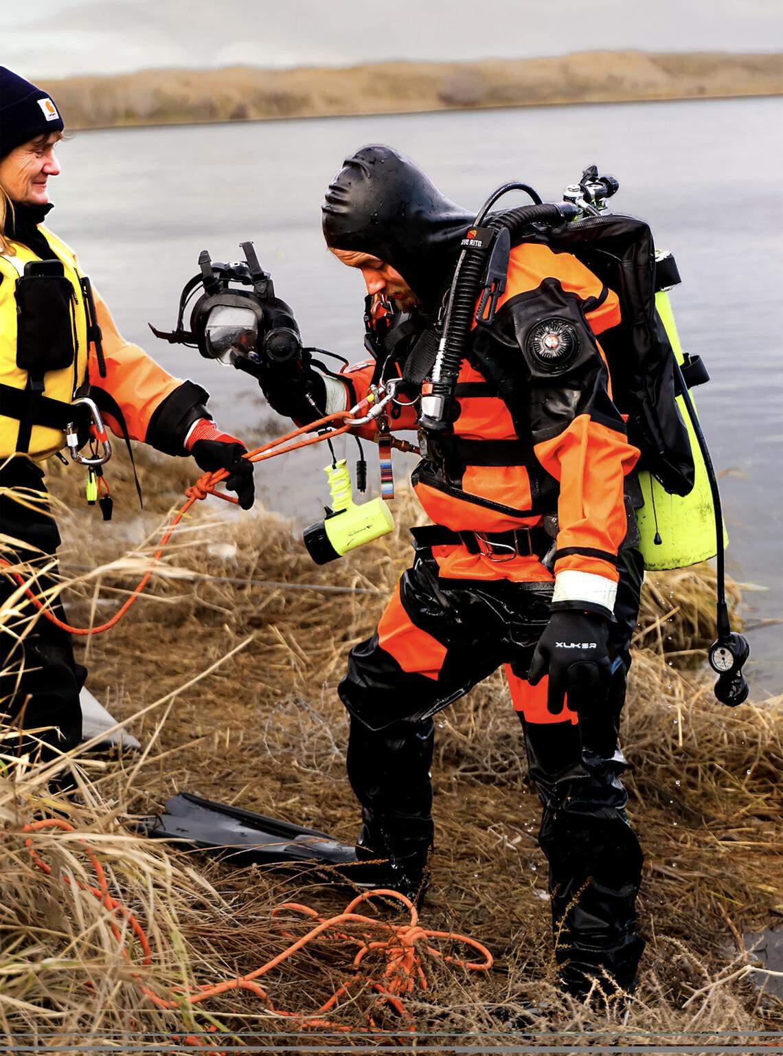 Jessie Bell, left, assists rescue diver Cyrus Stanley of the Columbia Basin Dive Rescue team as he exits the Columbia River after helping to recover a fully submerged Jeep near the Ringold Boat Launch, about 25 miles north of Pasco in Franklin County.