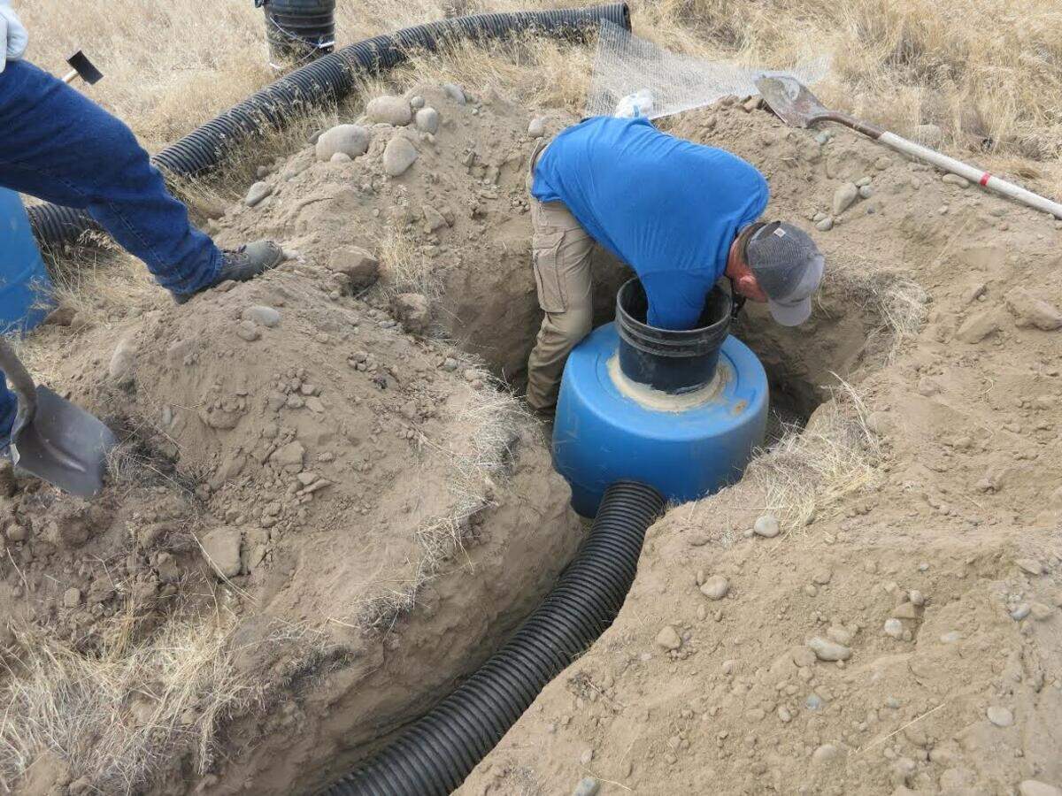 A Hanford worker installs half a 55-gallon drum in the ground at Hanford. It is intended as a nest for burrowing owls.