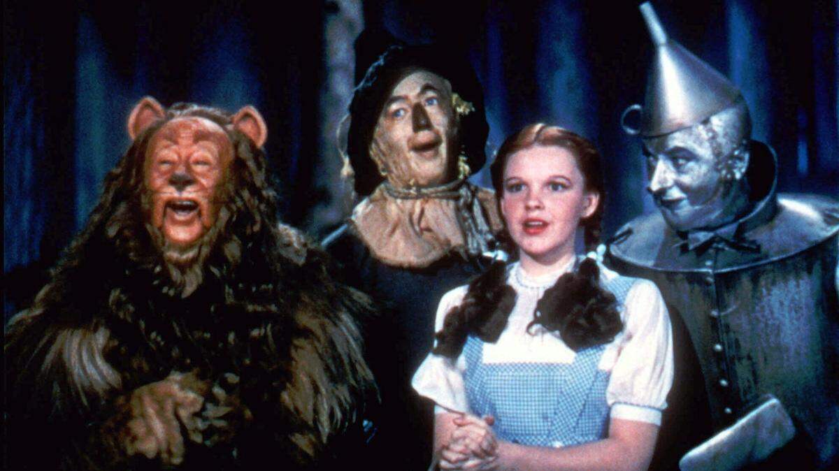 With Bert Lahr as the Cowardly Lion, Ray Bolger as the Scarecrow, Judy Garland as Dorothy, and Jack Haley as the Tin Woodman, the stars of ‘The Wizard of Oz’ sing together in this scene from the 1939 MGM classic film.