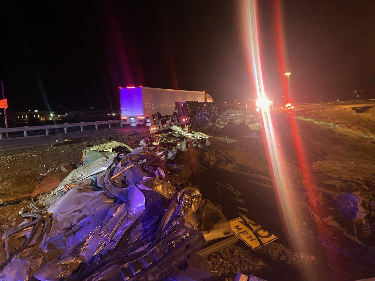 A semi carrying crushed cars flipped on Highway 395, spilling its load across the side of the road.