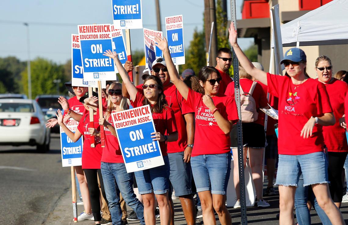 Striking Kennewick teachers and their supporters wave to passing motorists early Tuesday morning on West Vineyard Drive near Amistad Elementary School.