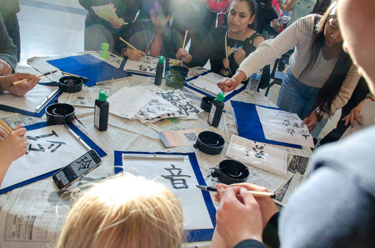 Japanese students from Yamate Gakuin Junior Senior High School lead children and community members in a “shodo” calligraphy activity at Chiawana High.