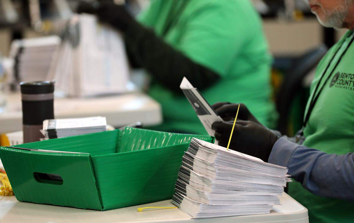 Benton County election workers open envelopes to prepare the submitted general election ballots for tabulation at the Benton County Elections Center in Kennewick.