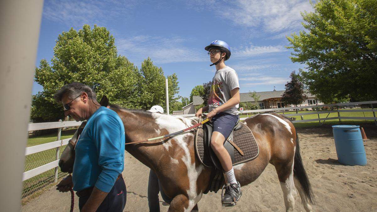 TROT volunteer Richard Alan leads a horse as Hunter Ford rides. The Pasco nonprofit is offering a new horsemanship class for people with disabilities but it wants to expand to others, such as veterans and people dealing with mental illness.
