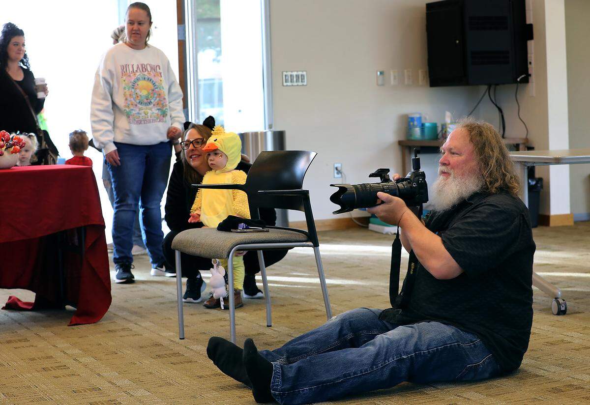 People wait in line as photographer Scott Butner takes free portraits of residents in their Halloween costumes Friday morning at the Richland Public Library. It's a tradition he's done for 16 years.