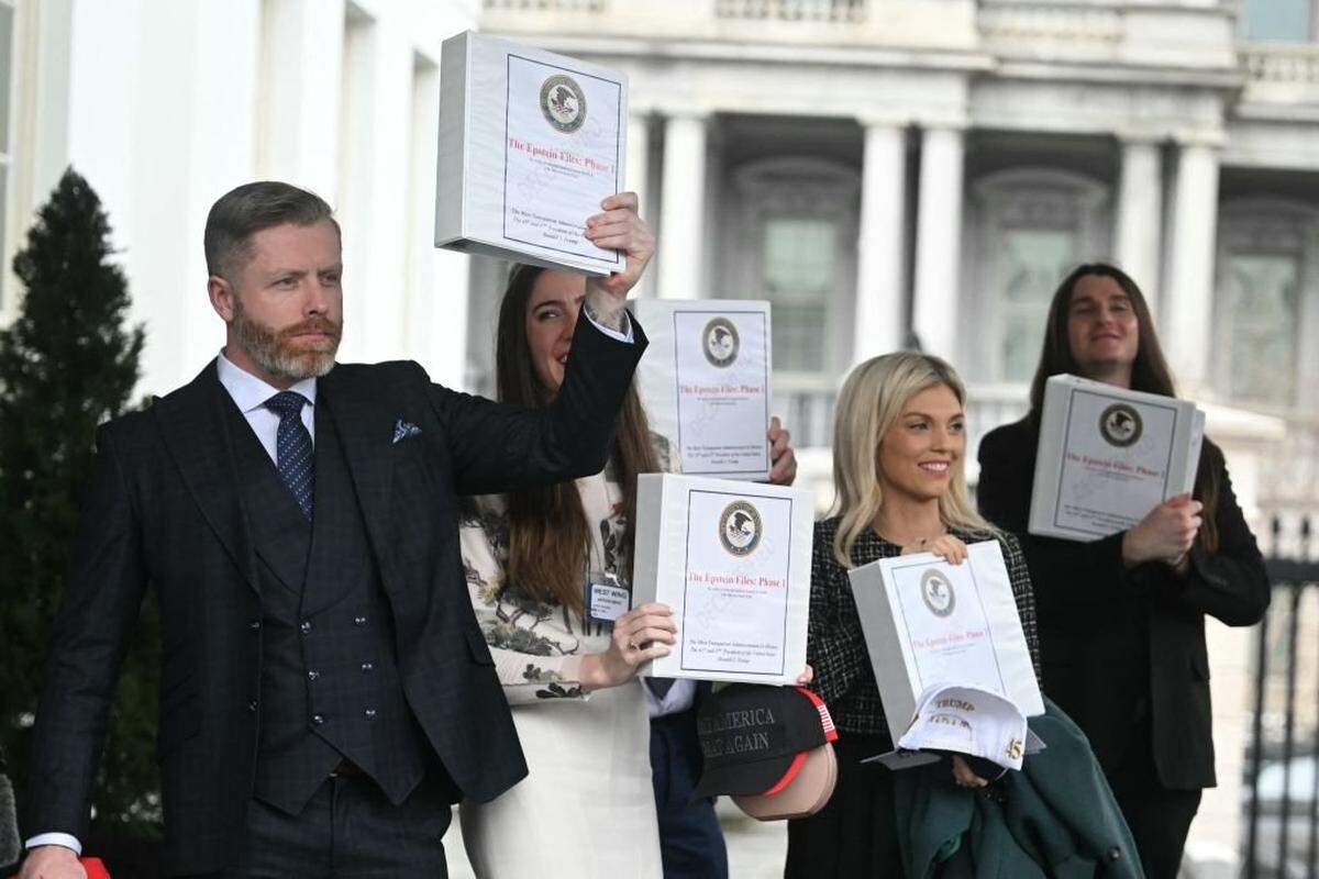 From left, Political commentator Rogan O'Handley, aka DC Draino, TikToker Chaya Raichik, commentator Liz Wheeler and U.S. conservative activist Scott Presler carry binders bearing the seal of the Justice Department reading "The Epstein Files: Phase 1" as they walk out of the West Wing of the White House in February 2025.