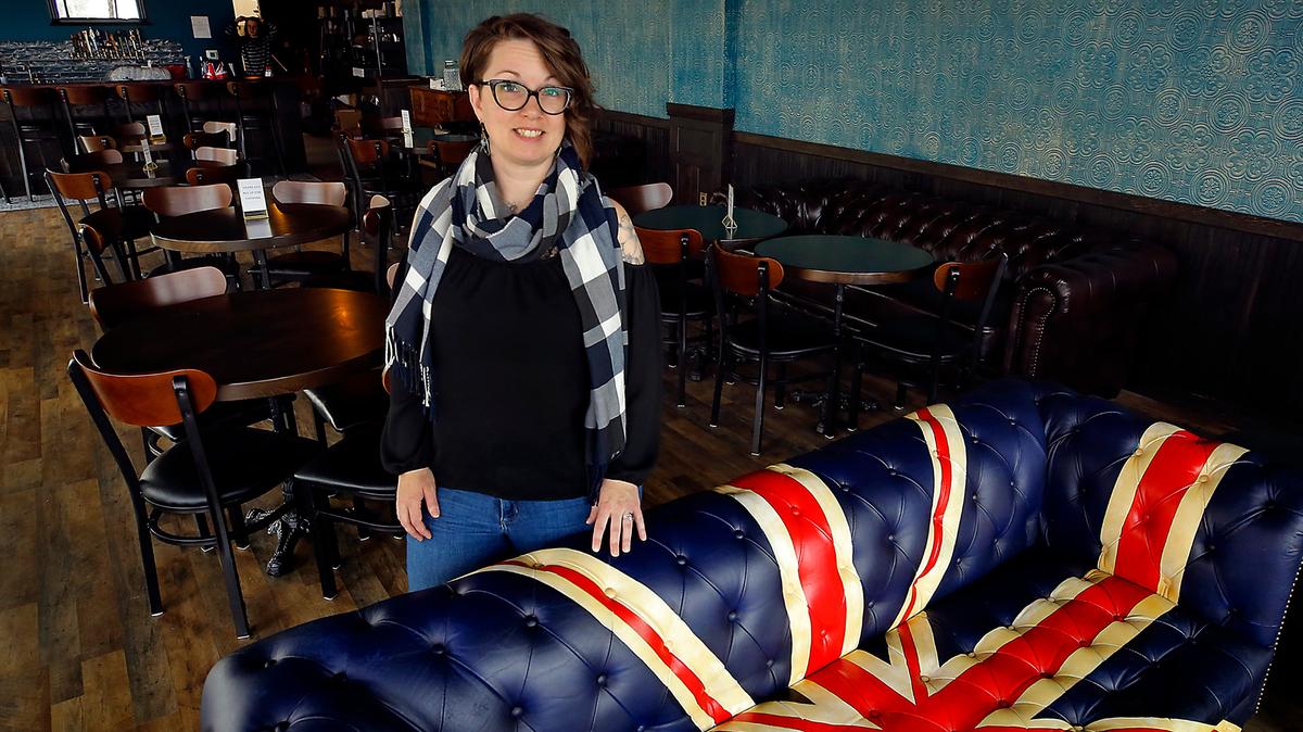 Shane Dozhier, co-owner of Blackthorne Neighbourhood Pub, stands next to the Chesterfield-style sofa painted with a bold Union Jack that welcomes guests enter the downtown Kennewick establishment.