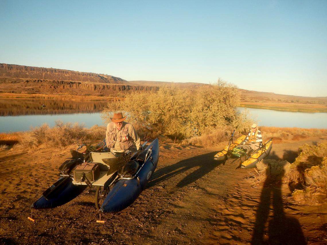 Fly casters Ken Gano and Ted Poston push their pontoon boats up the hill after a fine fall day of fishing on Lenice Lake.