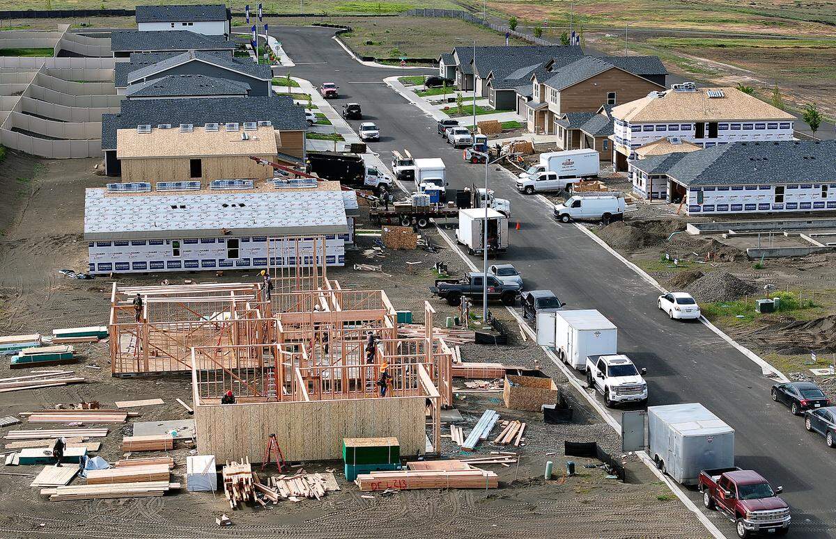 Construction crews work on building new homes on Road 115 in The Dunes housing development in west Pasco.