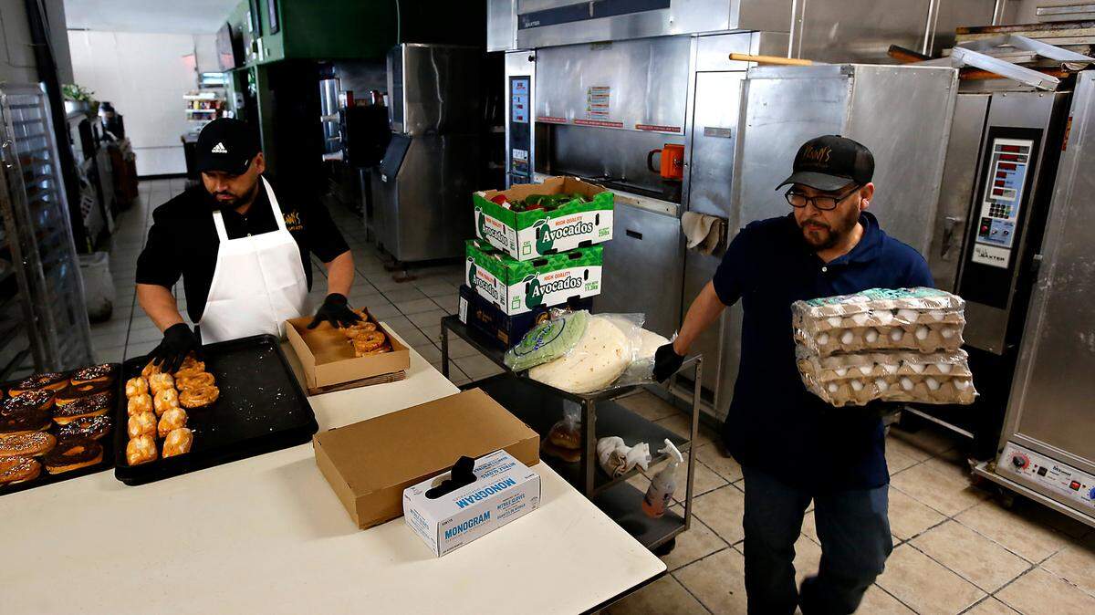 Vinicio “Vinny” Marín Gomez, owner of Vinny’s Bakery & Bistro in downtown Pasco, boxes up food to donate to the food bank after being forced to close his popular eatery.