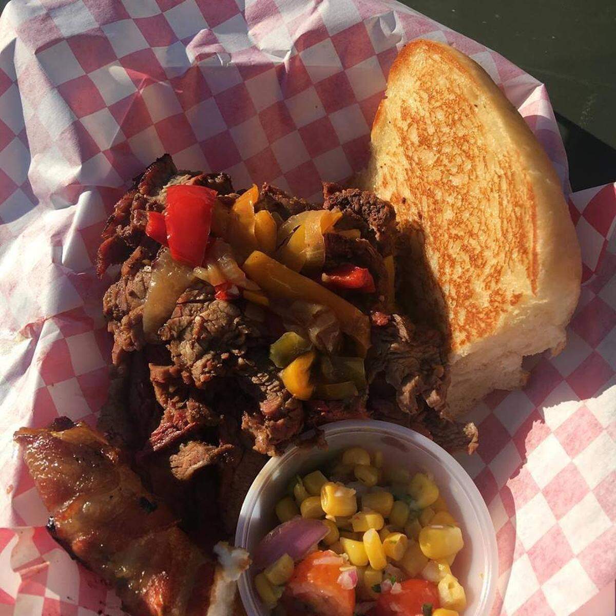 Swampy’s flank steak sandwich with sautéed peppers and onions with guacamole on a toasted bun.
