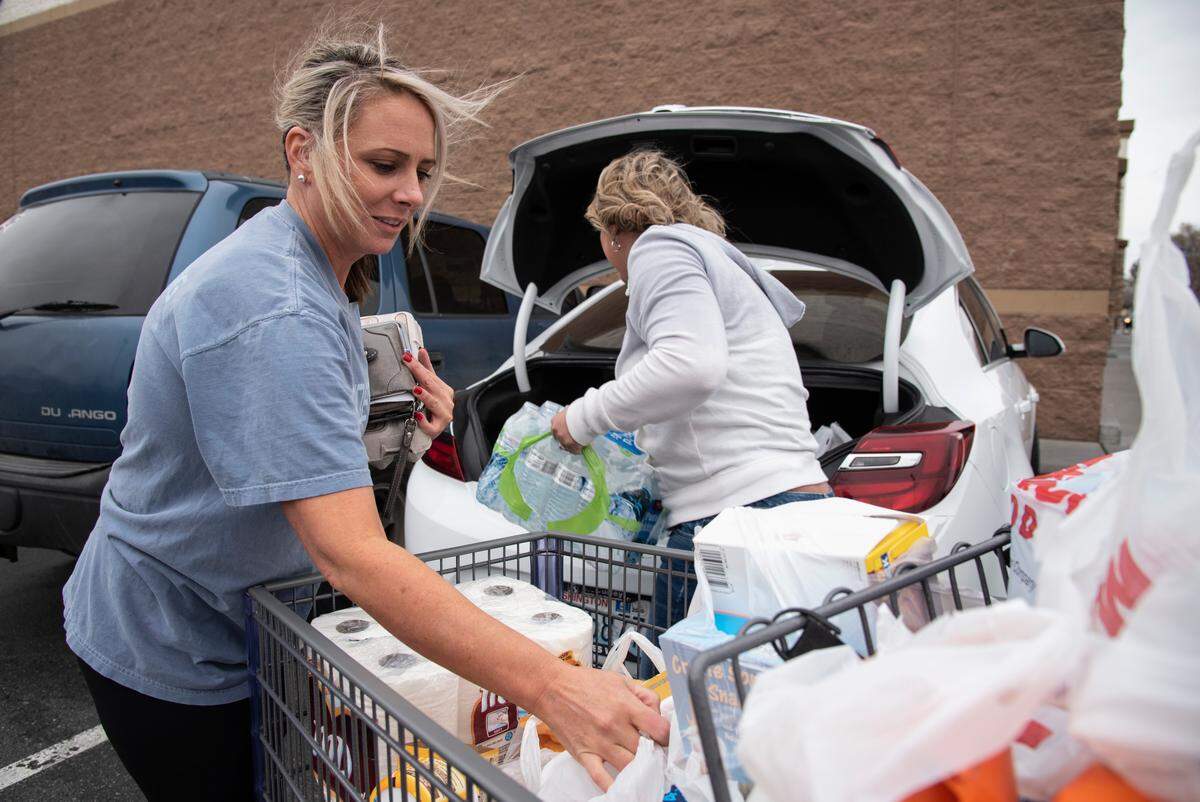 Tiffany Davis, 32, left, and Karen Hoffman, 43, both of Kennewick, load groceries into their car after stocking up on essentials at WinCo in Kennewick.