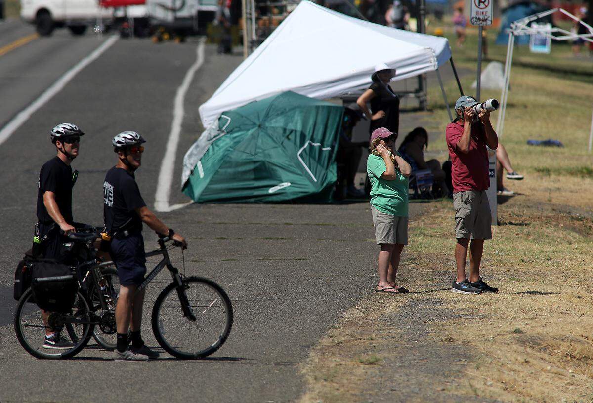 People along the Kennewick shoreline of the Columbia River stop to watch the F-35 fighter jet as it roars across the Tri-Cities during the Over The River Air Show performance.