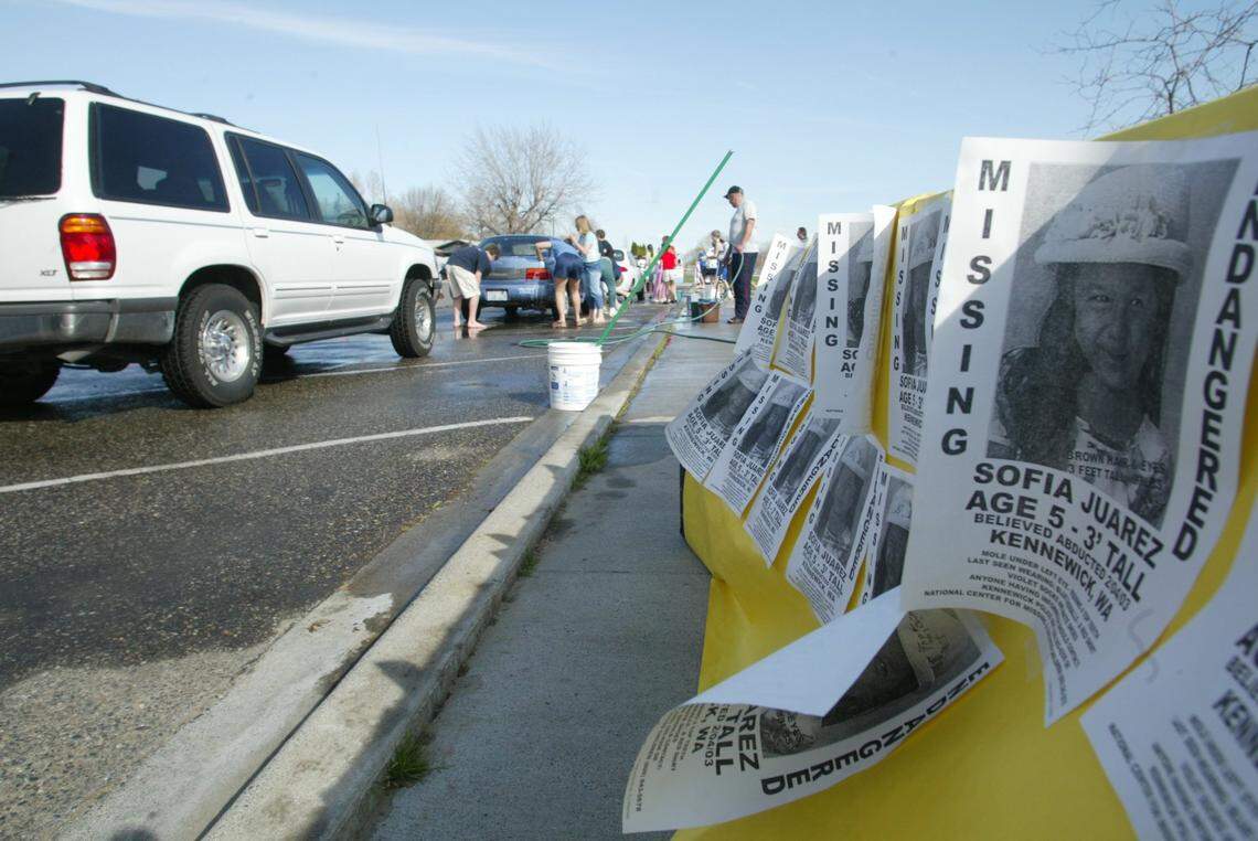Posters of Sofia Juarez line a table in March 2003 near Bethlehem Lutheran School in Kennewick during a car wash to raise money to help her family.