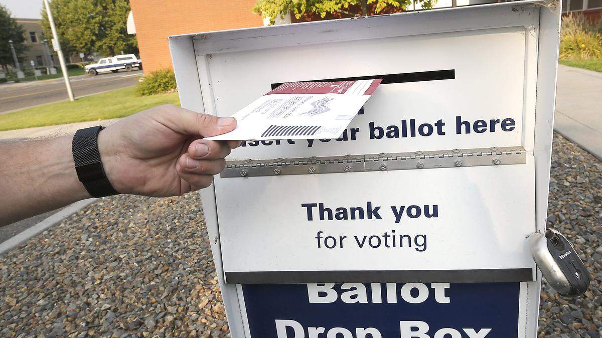 A Benton County voter drops off a ballot at the drop box at Kennewick City Hall.