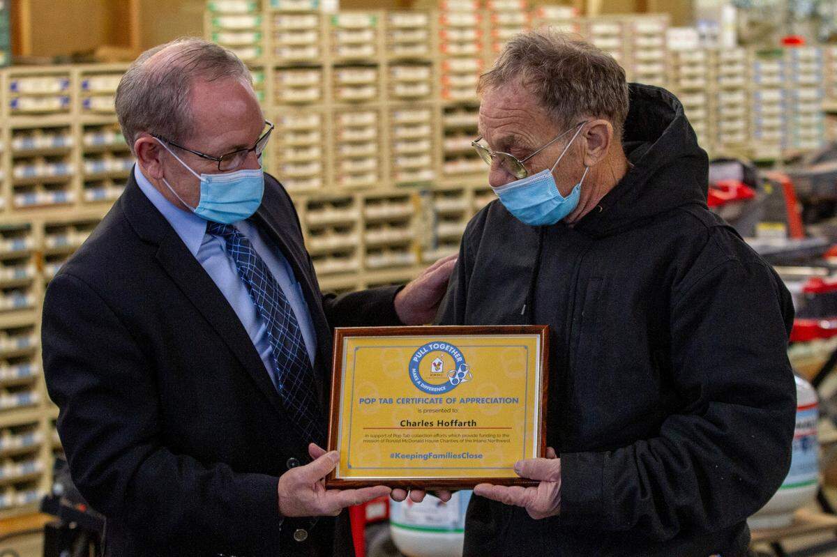 Bob McClean, Development Director of Ronald McDonald House of Spokane, presents Charlie Hoffarth with a certificate of appreciation for Hoffarth’s donation of 150 pounds of soda can pop tabs to the organization. Money from recycling the pop tabs goes directly to funding for the Ronald McDonald House Charities.
