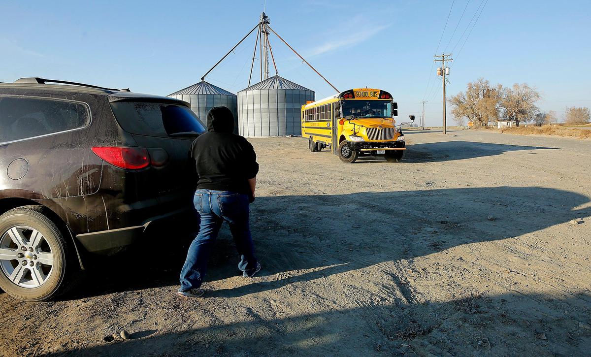 The mother of a Pasco high school student waits recently for the school bus to finish turning around in the dirt lot near a grain silo on Peterson Road just off the Pasco-Kahlotus highway in rural Franklin County. Watch a video at: tricityherald.com/video