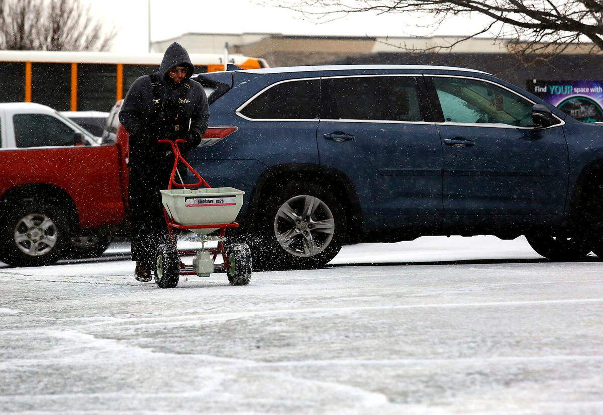 Justin Merrill of ABV Pest, Windows & More, spreads a layer of ice melt in the parking lot of an office building off South Union Street early Wednesday morning in Kennewick. An overnight snowstorm coated much of the Mid-Columbia and created hazardous driving condition in man areas.