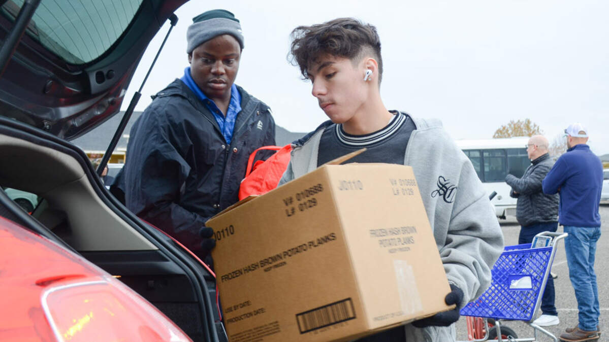 Volunteers pack Thanksgiving meals in the back of cars and trucks Saturday at Morning Star Baptist Church in Pasco, Wash. Local Tri-City faith leaders, in partnership with DoorDash, expected to hand out 105 ham-and-turkey meals to local families in need.