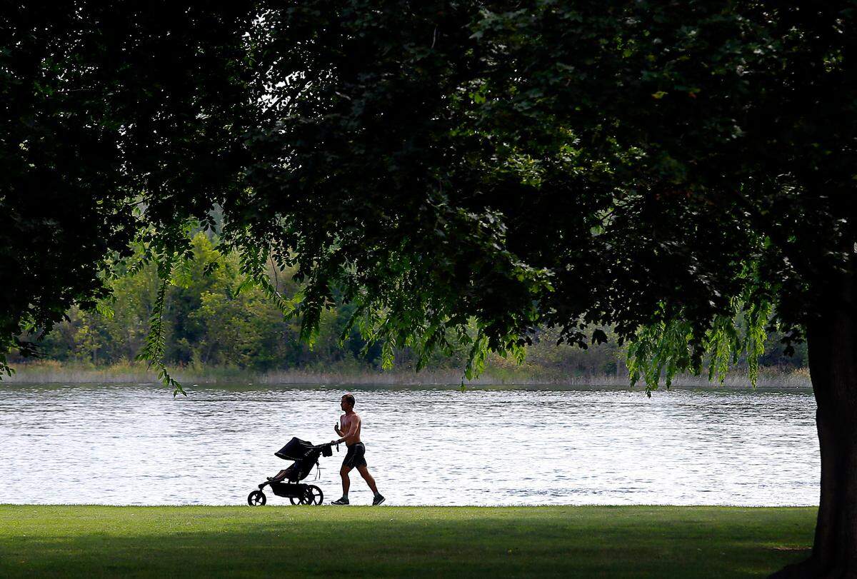 An early morning jogger pushes a stroller alongside the Columbia River on the pathway through Richland’s Howard Amon Park. 