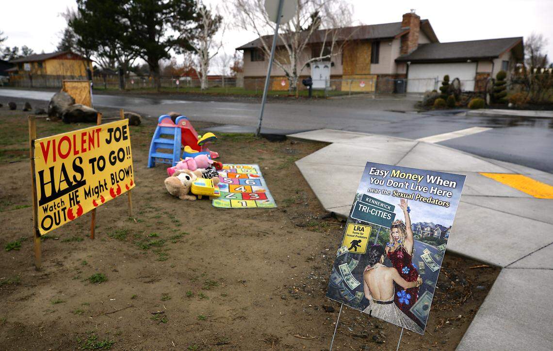 Neighbors in the area off West Eighth Avenue have placed signs, various children's toys and stuffed animals along Edison Street in Kennewick opposing allowing a home for sex offenders. 