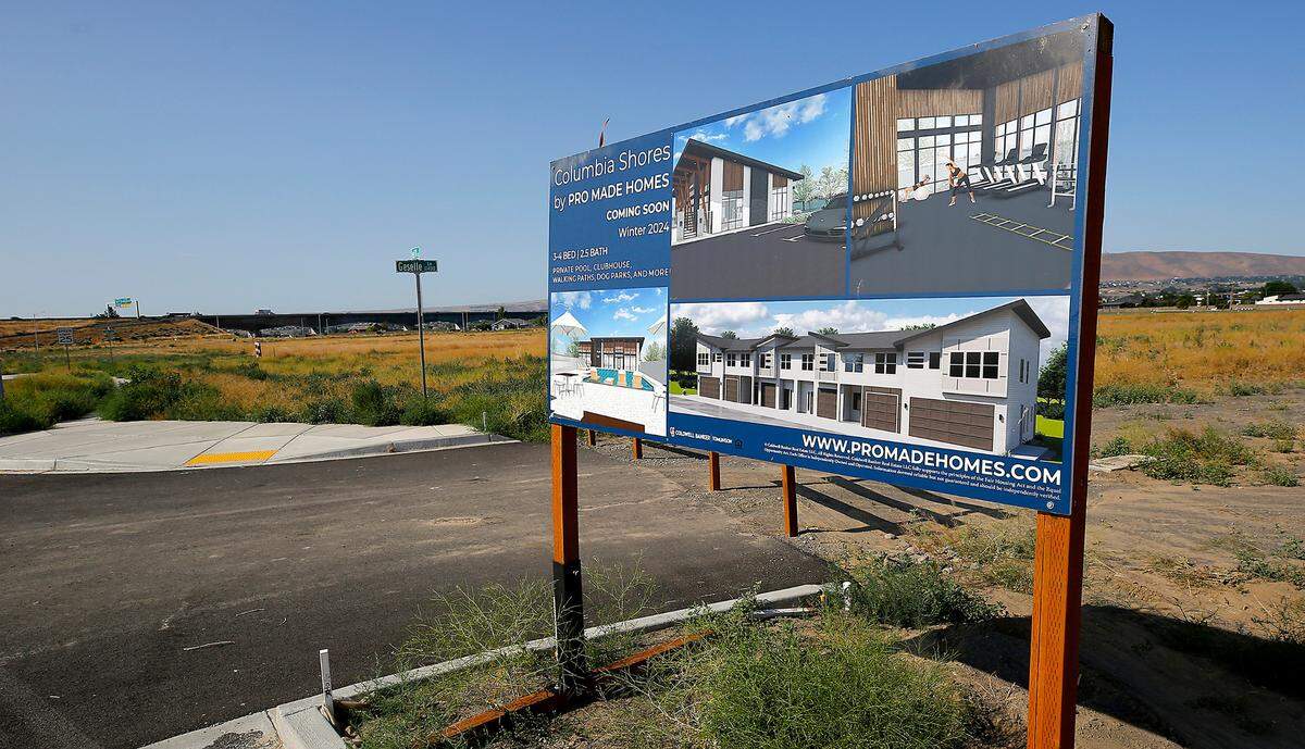 A sign provides contact information and conceptual drawing for the Columbia Shores housing development on Road 114 at Geselle Lane in west Pasco.