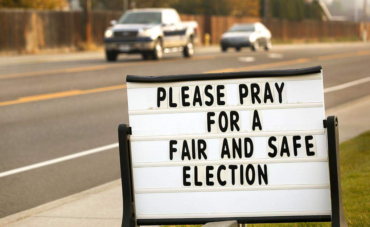 Motorists drive past a sign calling to pray for a fair and safe election on at Hillview Baptist Church in the 1600 block of West 27th Avenue in Kennewick.