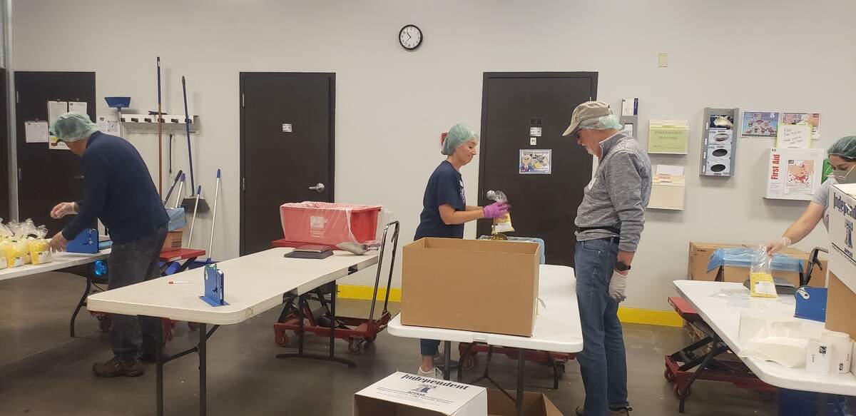 Second Harvest volunteers separate bulk corn into smaller packages before distribution