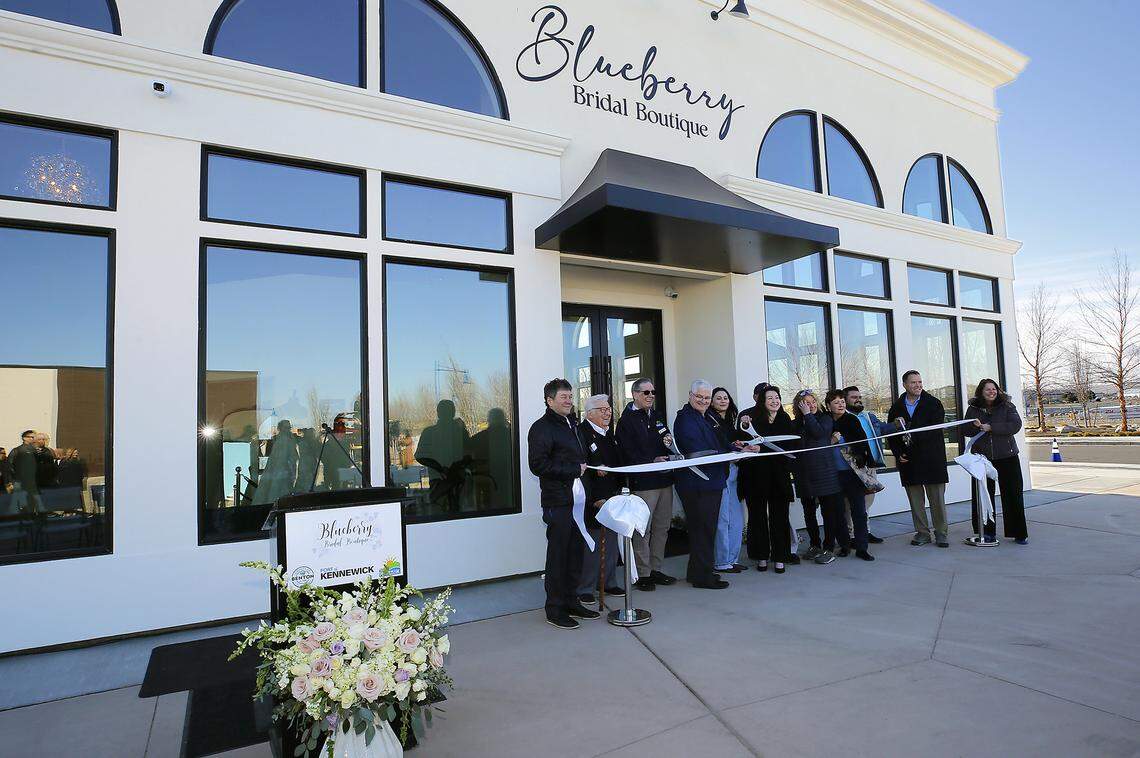Owner Amber Keller is surrounded by family, friends and local dignitaries for the ribbon cutting ceremony at Blueberry Bridal Boutique in Kennewick.