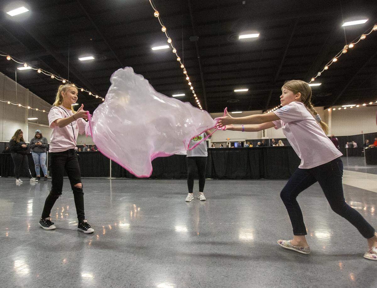 London Albright, left, and Lizzi Owens, both 11, play with slime during Slime in the 509 at TRAC in Pasco on Saturday. Twelve-year-old Brook Poderick of Kennewick came up with the idea for the event.