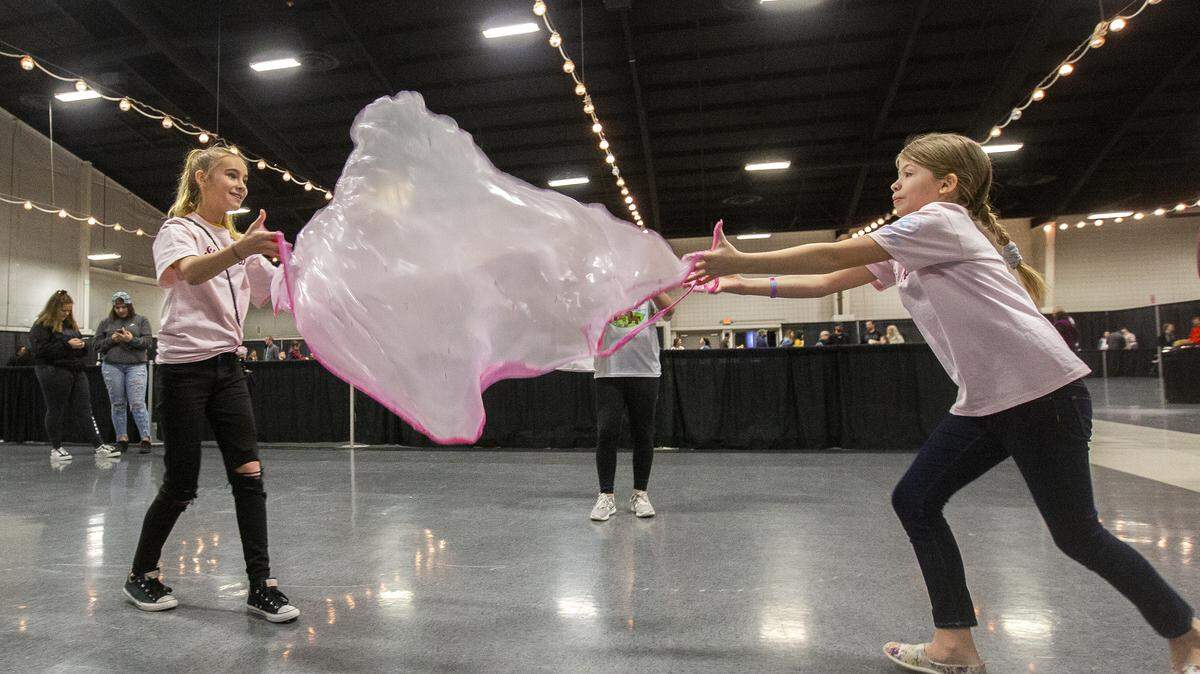 London Albright, left, and Lizzi Owens, both 11, play with slime during Slime in the 509 at TRAC in Pasco on Saturday. Twelve-year-old Brook Poderick of Kennewick came up with the idea for the event.