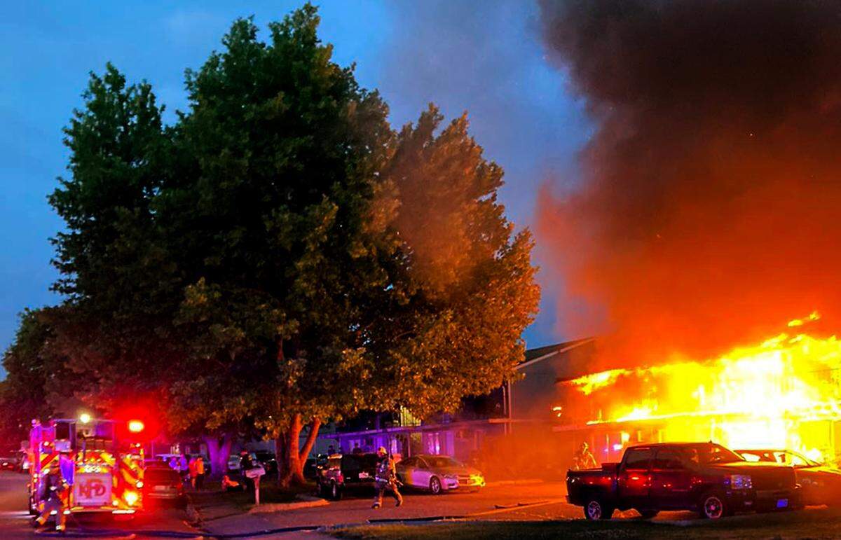 Kennewick Fire crews work to extinguish a structure fire in the 1000 block of North Cleveland Street early Thursday morning in Kennewick. All residents were evacuated but both top story occupants had to exit through windows. Minor injuries were reported and all occupants were checked at the scene by paramedics.