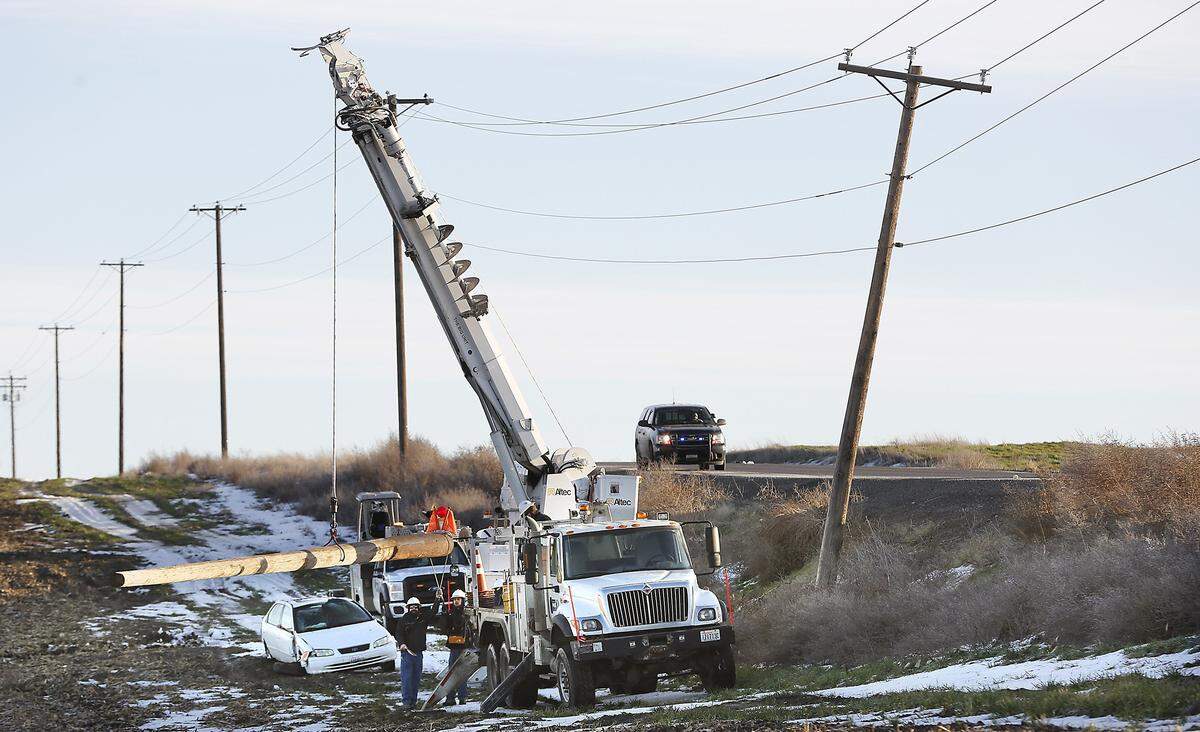 Utility workers from the Franklin County PUD prepare to replace a power pole damaged by a car wreck on the Pasco-Kahlotus Highway about three miles from Pasco.