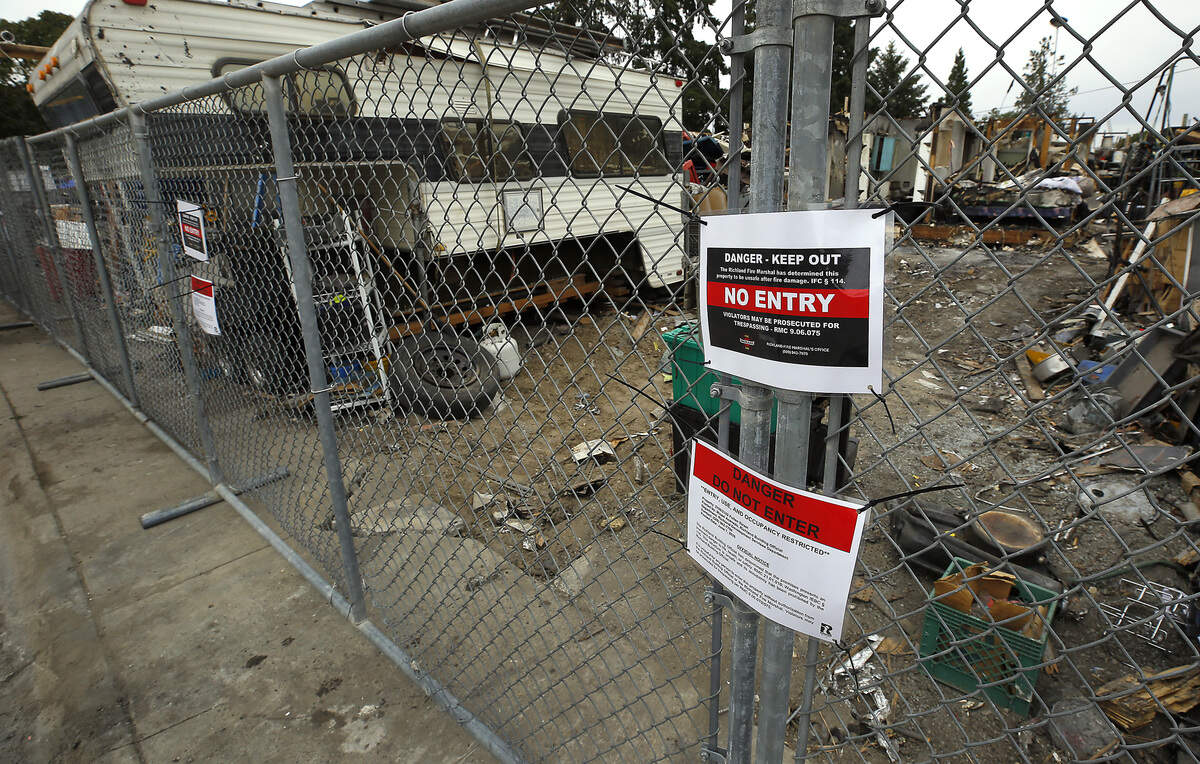 A temporary construction fence surrounds the burned remnants of the "junkyard" house on Pullen Street in Richland.