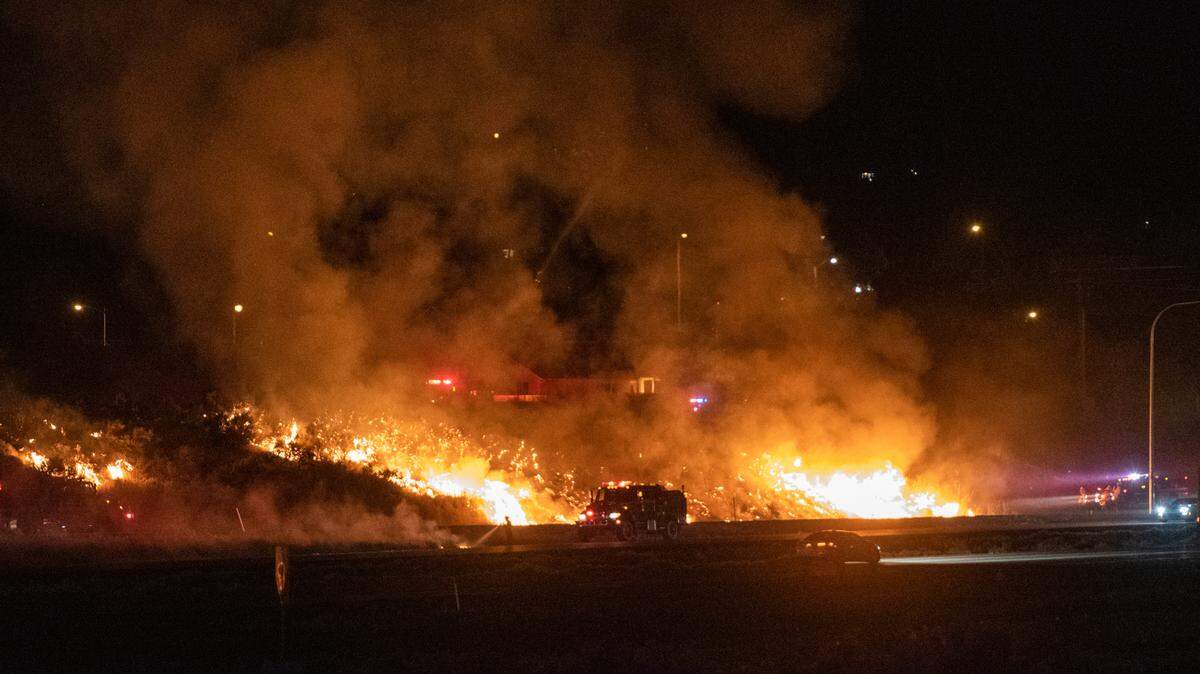 A brush fire that appeared to start in several places along Interstate 182 in south Richland threatened nearby homes and buildings.