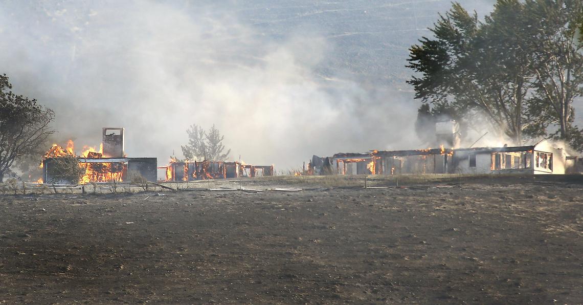A home at the south end of South Ely Street burns unchecked Saturday after a wind-driven wildfire raced across the hill from the Bofer Canyon area into south Kennewick. Several homes were destroyed by the fast moving flames. Watch videos at: tricityherald.com/video