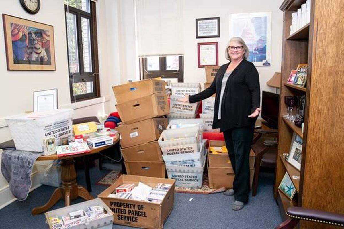 Sen. Maureen Walsh poses with the avalanche of mail and playing cards that have arrived in her office.