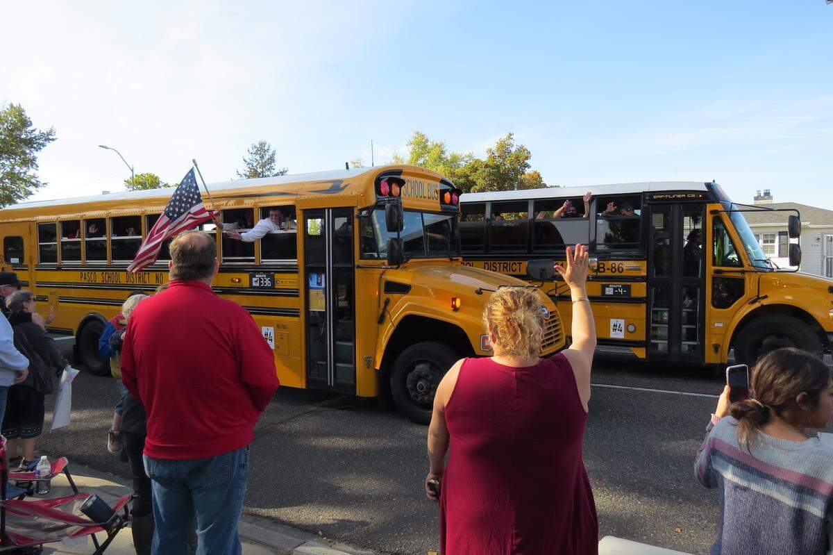 People waved at buses as part of a parade to remember slain bus driver Dick Lenhart Saturday.