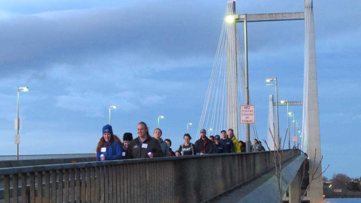 About 200 people crossed the cable bridge between Kennewick and Pasco on Friday carrying lights in the second annual Human Trafficking Awareness Walk. The event symbolizes that survivors of human trafficking are not alone, and the community supports them, said Desiree Reynolds with the Support, Advocacy and Resource Center.