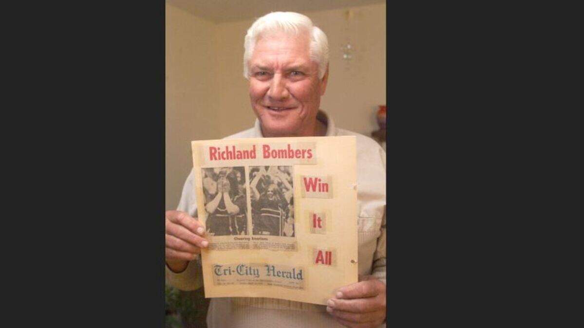 In this 1999 photo, former Richland High basketball coach Frank Teverbaugh holds a newspaper clipping from the Bombers’ 1972 state championship. The beloved former coach died Aug. 28.