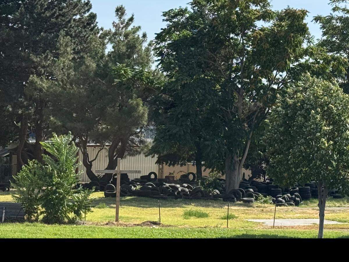 A growing pile of tires and other debris can be seen from a nearby walking trail along the Columbia River in Kennewick.