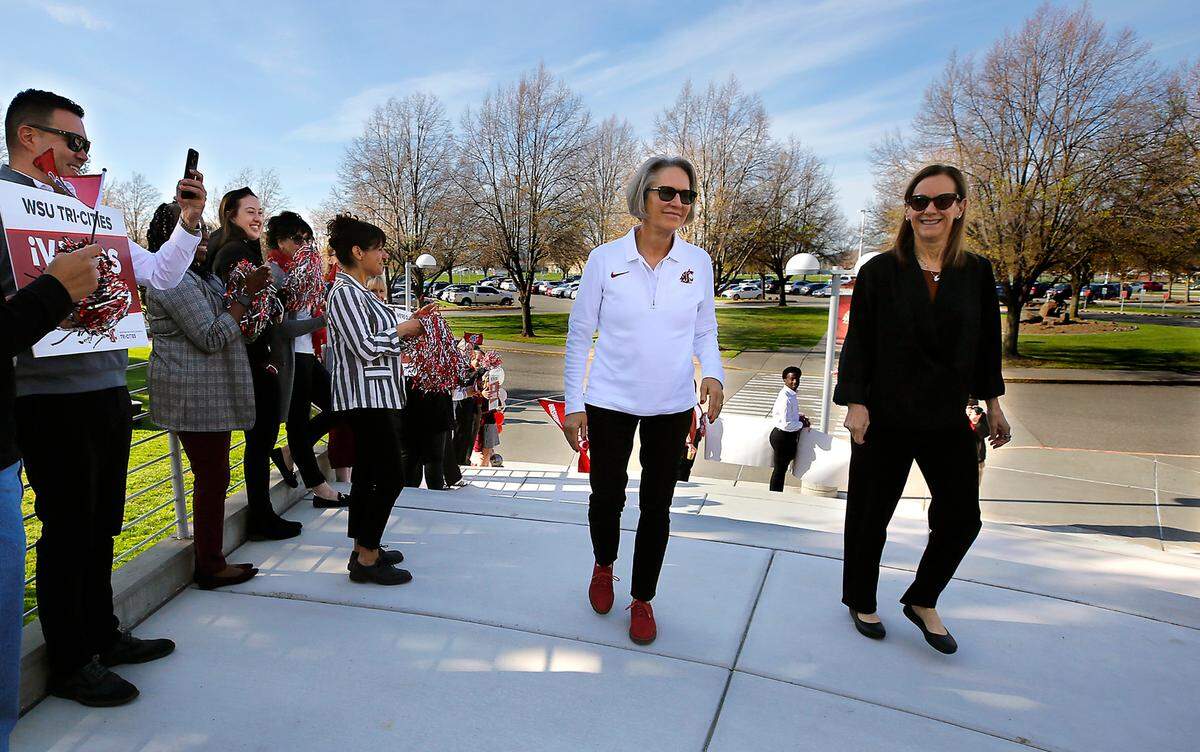 New WSU President Elizabeth Cantwell, left, walks past a cheering welcoming party with Chancellor Sandra Haynes on Wednesday during her first visit to the WSU-Tri-Cities campus in Richland.