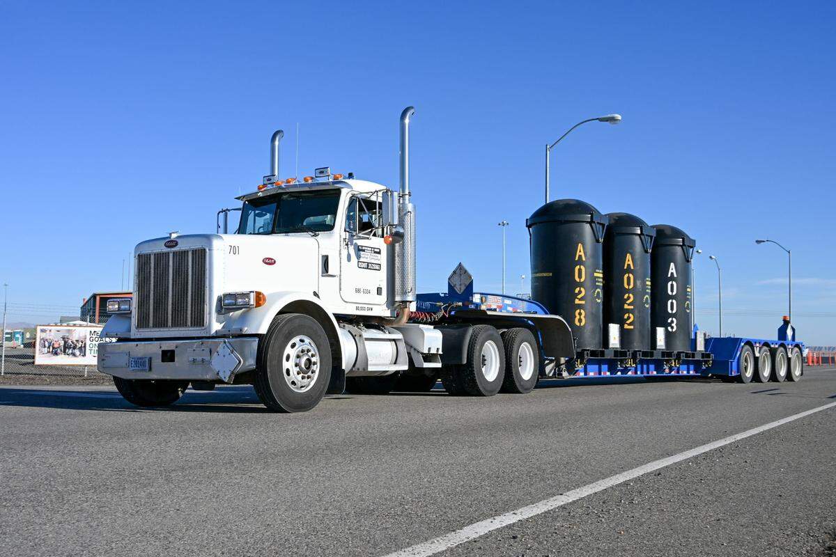 Three containers of vitrified radioactive waste are hauled to the Hanford nuclear site’s Integrated Disposal Facility.
