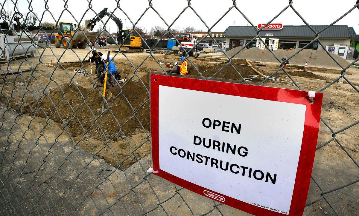 Signs posted on the temporary construction fence informs customers that the Jacksons convenience store at 1400 W. 27th Ave. in Kennewick remains open while construction crews work on the gas pumps.