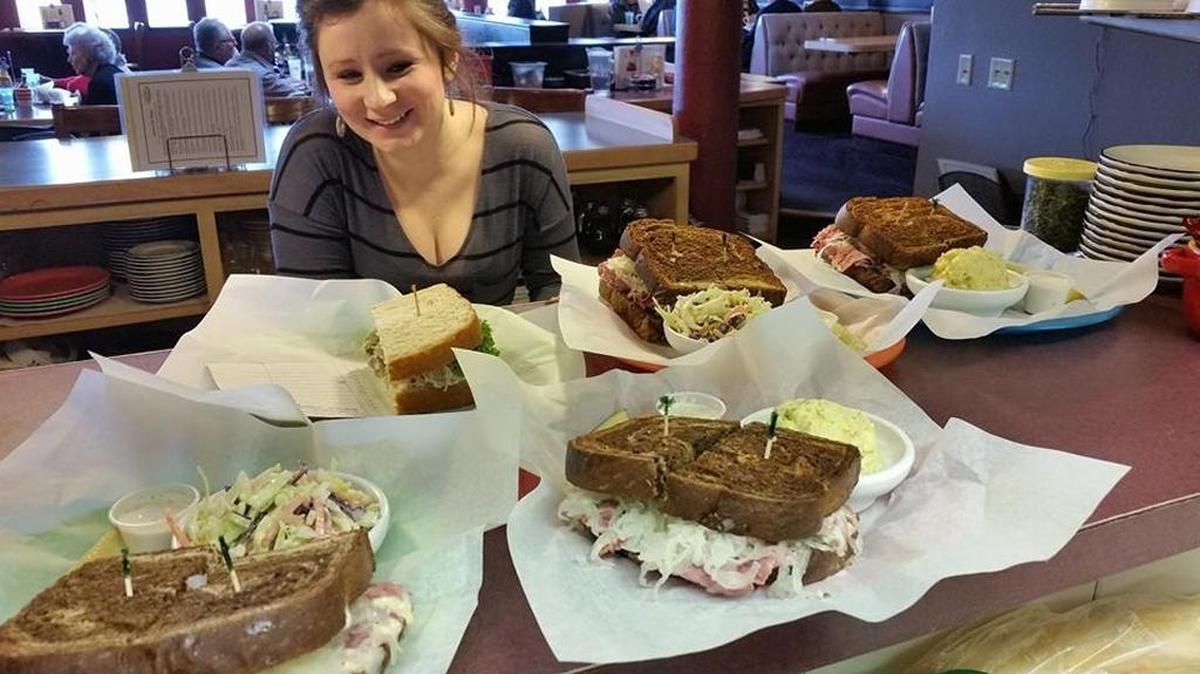 Server Kayla Zoesch serves up sandwiches and sides at the Village Bistro in Kennewick. The Marineland Village restaurant is under new ownership.