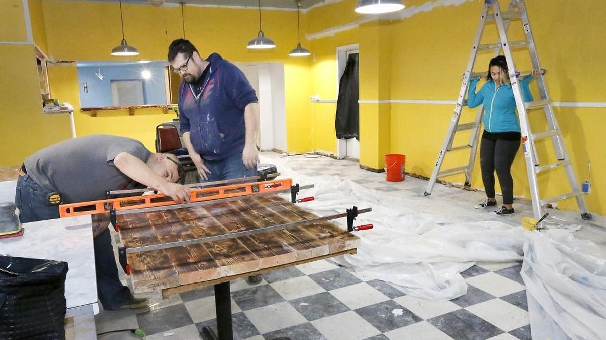 James Kari, left, and Robert VanSlycke work together Tuesday constructing a countertop as Amber Woods repositions a ladder for painting a wall in the former O’Henry’s Go Go restaurant at 20 S. Auburn St. in downtown Kennewick. Woods and VanSlycke are two of three business partners remodeling the space for a new eatery called Downtown Diner. It will serve traditional diner fare, such as burgers and sandwiches, but also have a Southern influence.