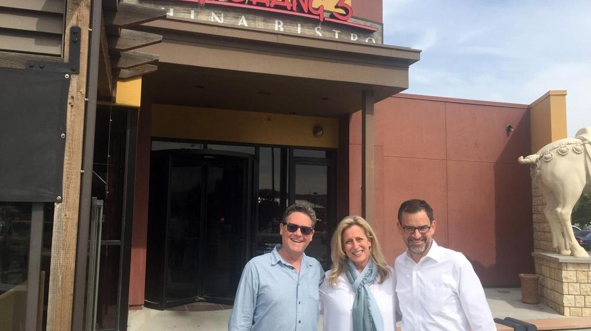 Winemaker John Freeman stands with Mary Melton of P.F. Chang’s and Precept CEO Andrew Browne in front of P.F. Chang’s China Bistro in Kennewick, Wash.