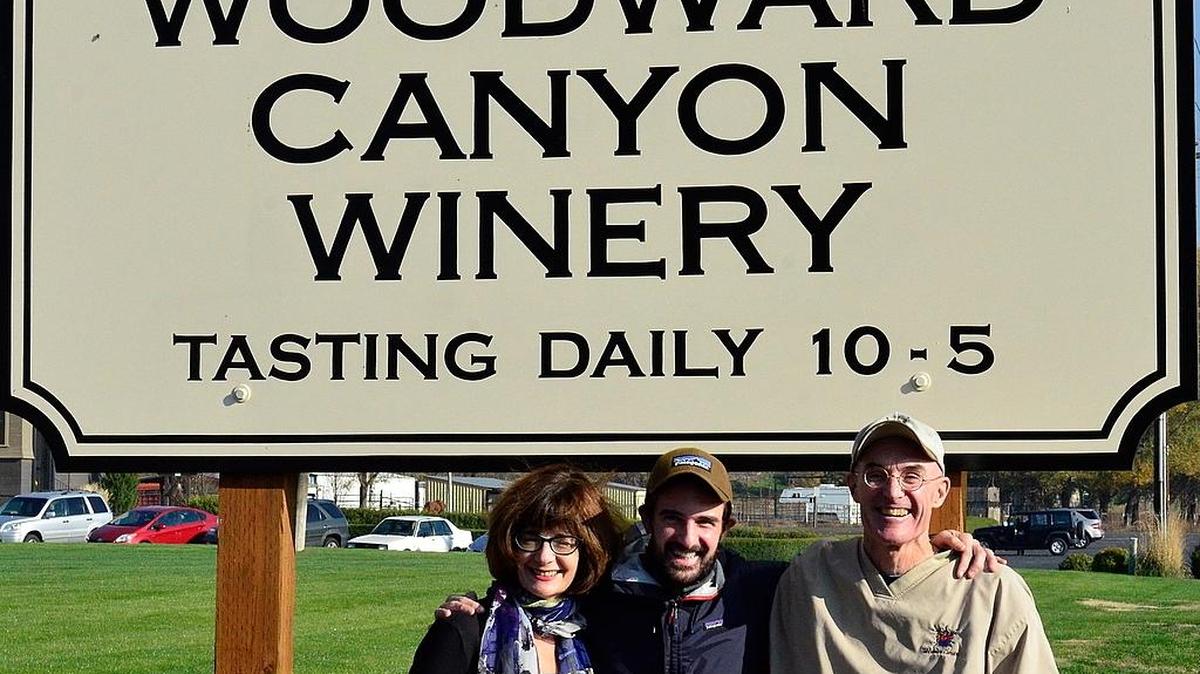 The sign is clear that the transition at Woodward Canyon Winery in Lowden has begun, because winemaking student Sager Small, center, is flanked by his parents, Darcey Fugman-Small and founding winemaker Rick Small.