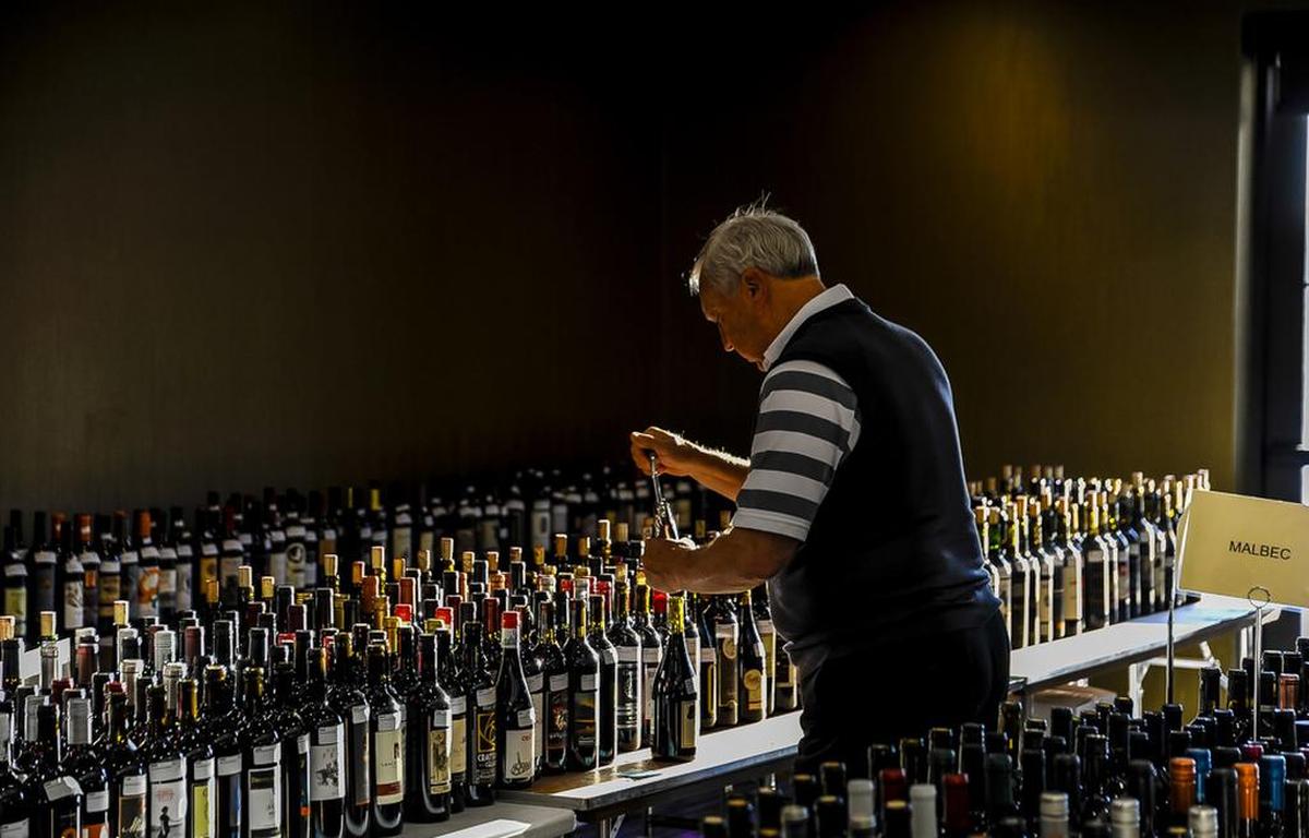 Mike Rader of Kennewick, Wash., uncorks bottles of wine in preparation for the 2019 Cascadia International Wine Competition in Richland, Wash.