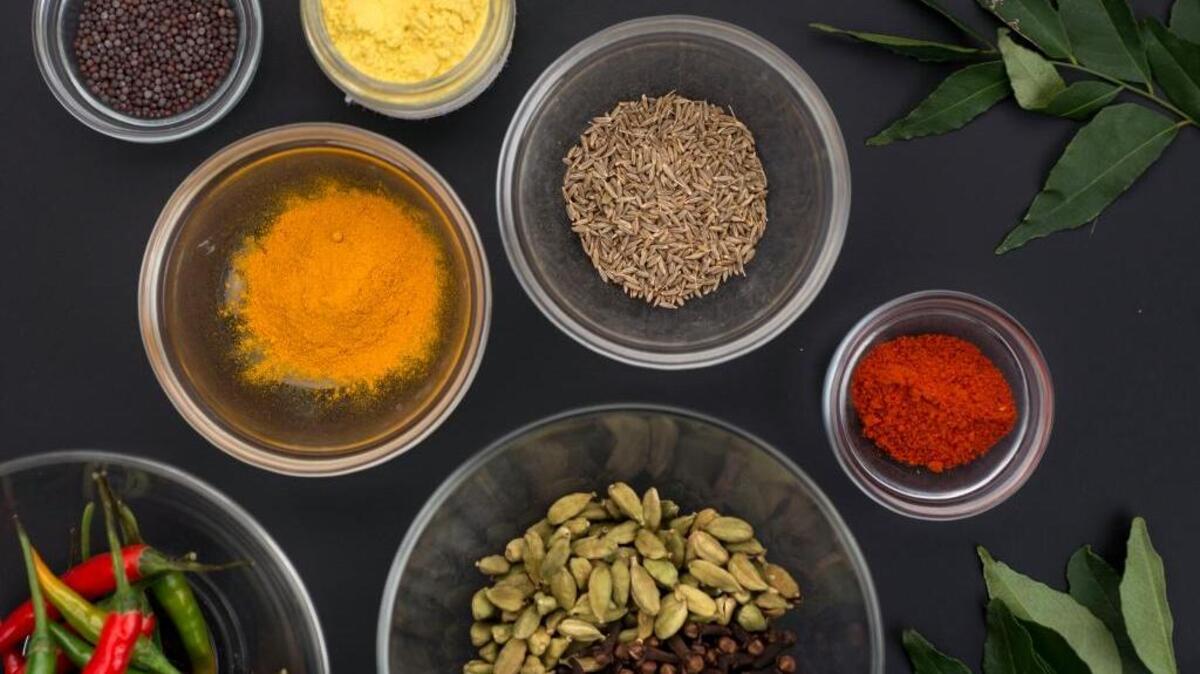 An assortment of spices used in Indian cuisine, including chili peppers, cardamom, cloves, red chilli powder, turmeric, asafoetida, cumin seeds, black mustard seeds and curry leaves. In general, don’t freeze or refrigerate seasonings, unless it is red-color spices, which can be refrigerated to stop loss of color and flavor. Also, oil-rick seeds like sesame can also be stored in the fridge or freezer.